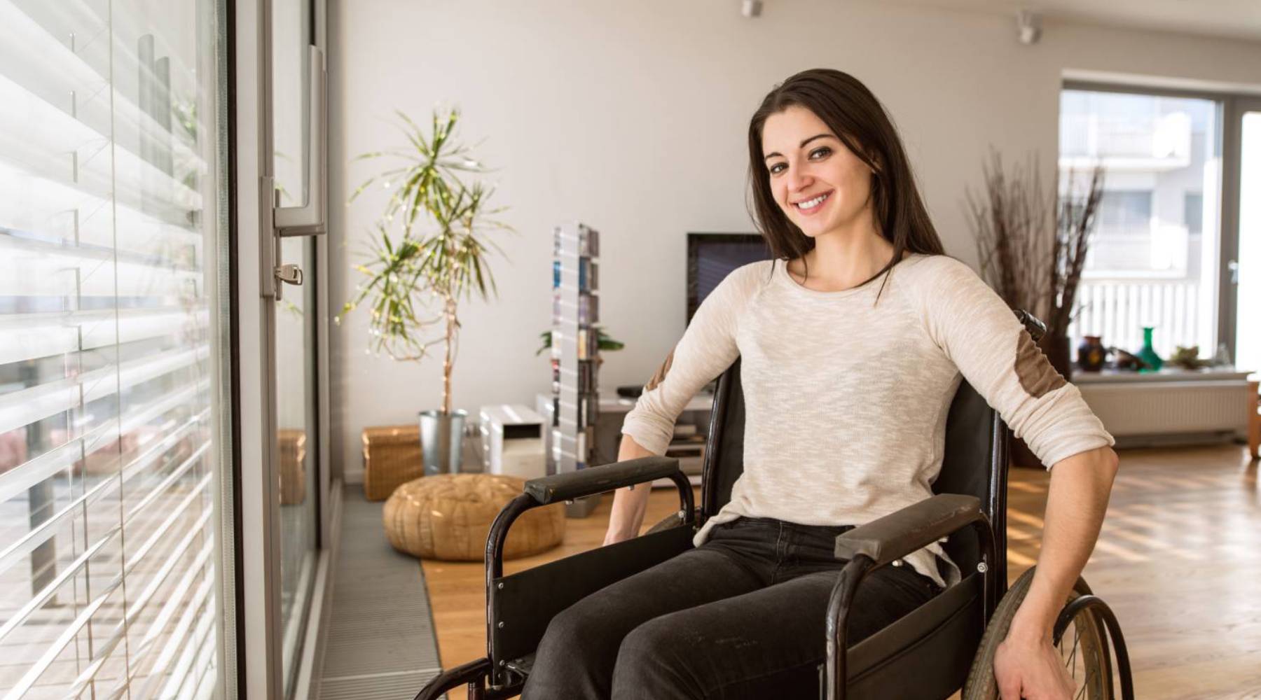 disabled woman in wheelchair at home in living room.